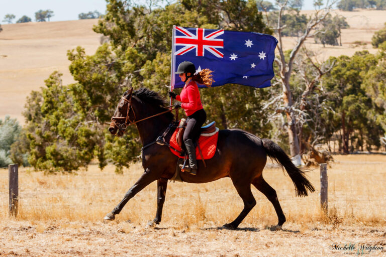 Miss B riding on Australia Day with Jackson whilst holding the Australian Flag
