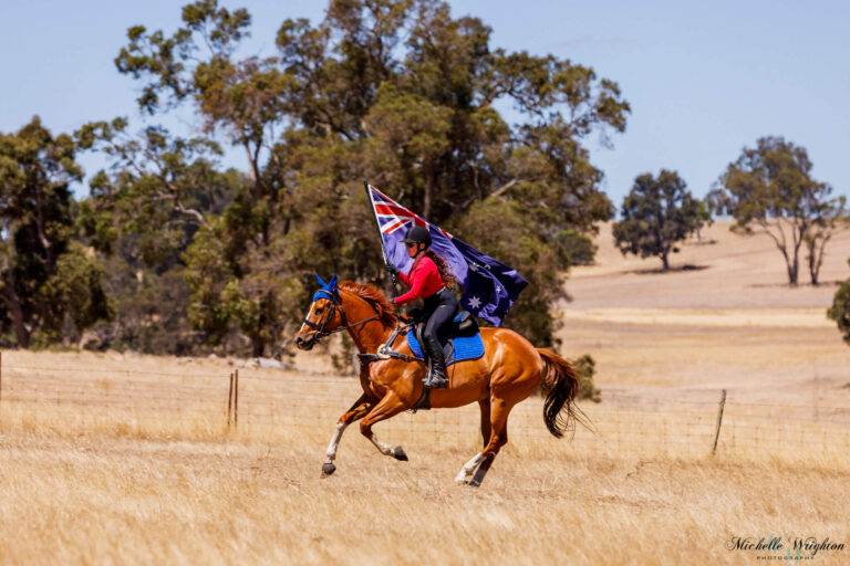 Miss B riding with Flame on Australia day holding the Australian flag